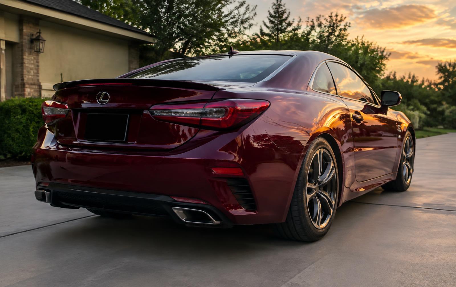 Glossy burgundy coupe reflecting the sunset after a full detail